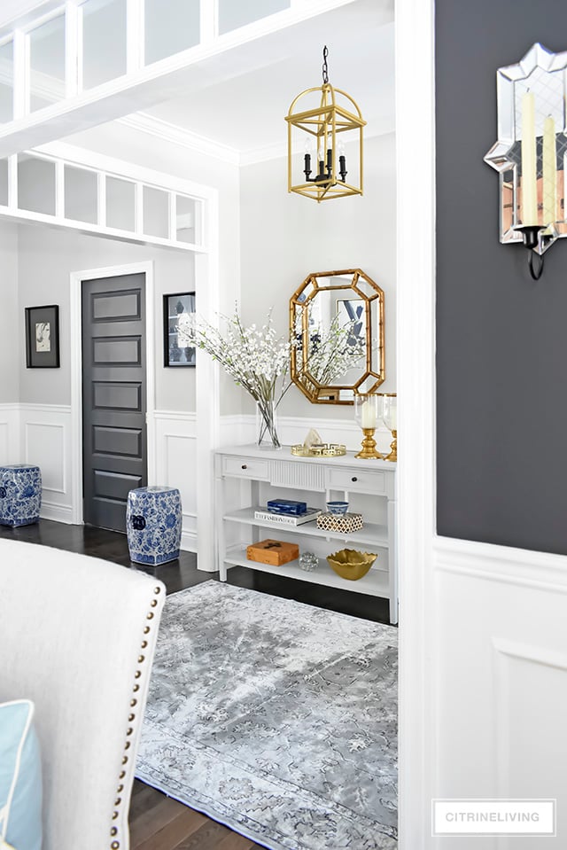 A light and bright entryway makeover that was super simple to achieve! Some chalk paint, a new mirror and new rug have completely transformed this foyer!