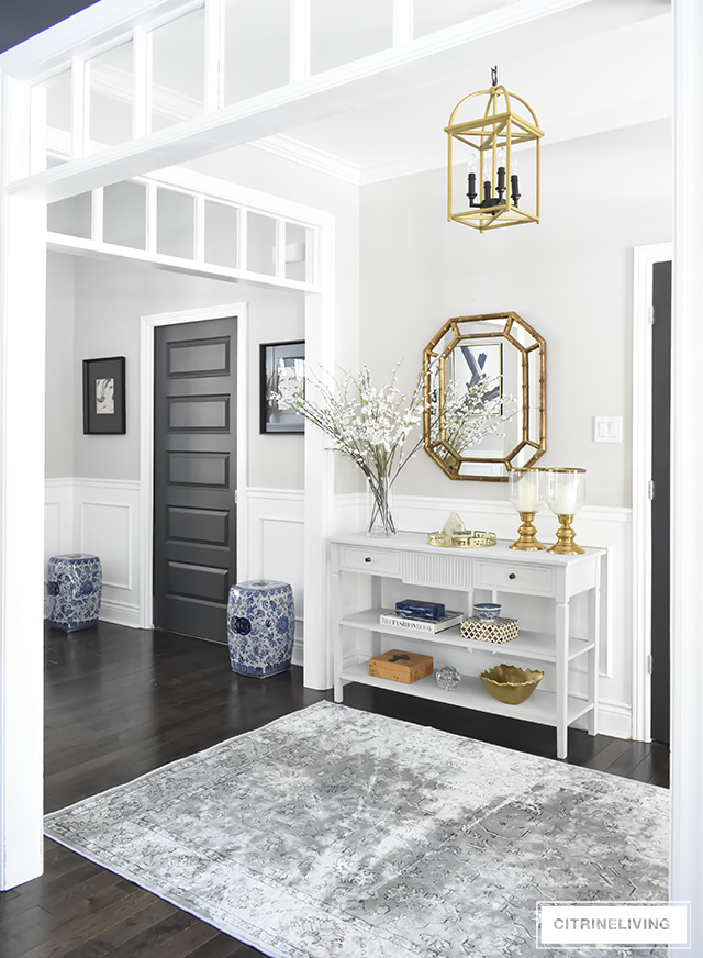 A light and bright entryway makeover that was super simple to achieve! Some chalk paint, a new mirror and new rug have completely transformed this foyer!