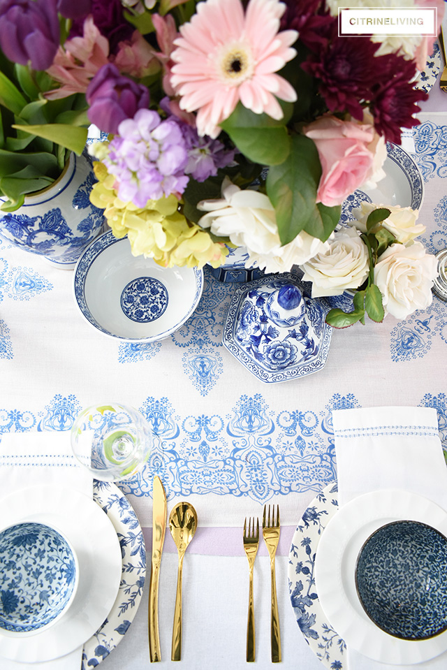 Beautiful blue and white tablescape accented with bright vibrant fresh and faux florals.