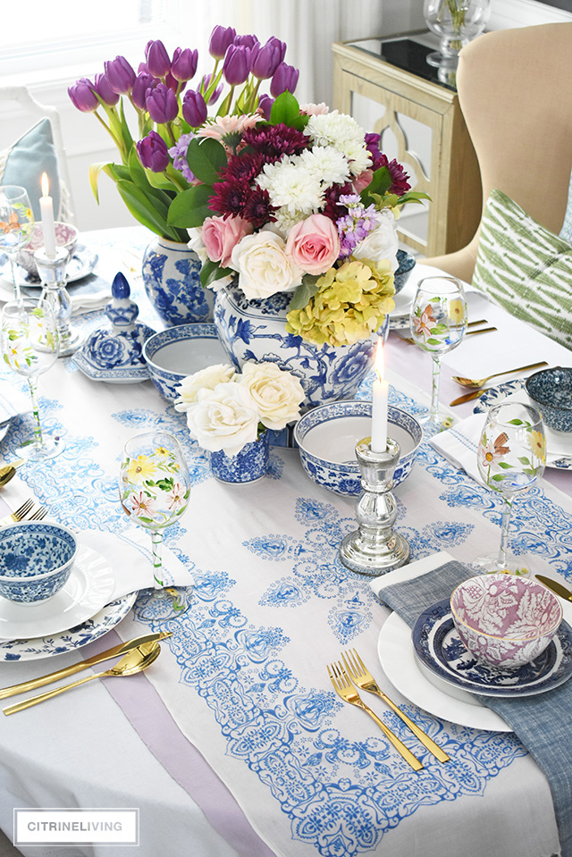 Beautiful blue and white tablescape accented with bright vibrant fresh and faux florals.