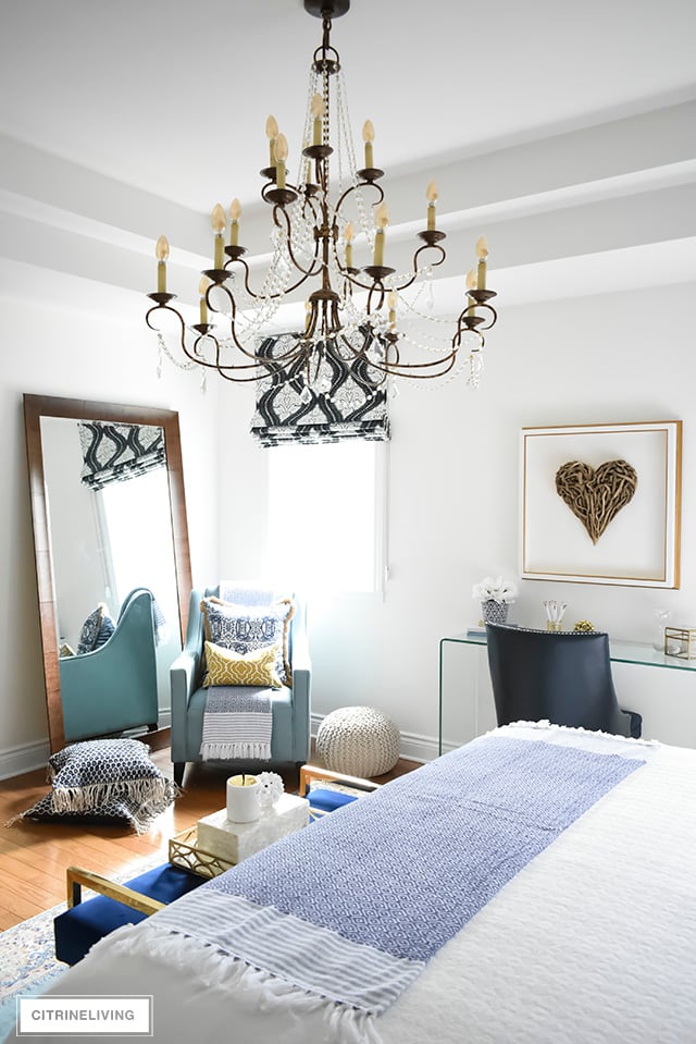 A gorgeous reading nook with layers of blues - vintage rug, eclectic pillows, graphic roman blind are layered together create the perfect boho-glam bedroom.