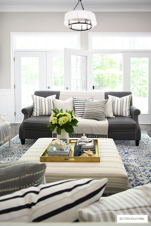 Create a casual and elegant summer living room with calming neutrals, layers of textures and hints on blue and white for a relaxing, laid-back look.