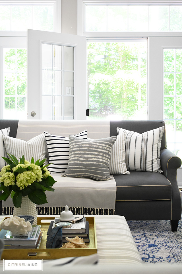 Create a casual and elegant summer living room with calming neutrals, layers of textures and hints on blue and white for a relaxing, laid-back look.