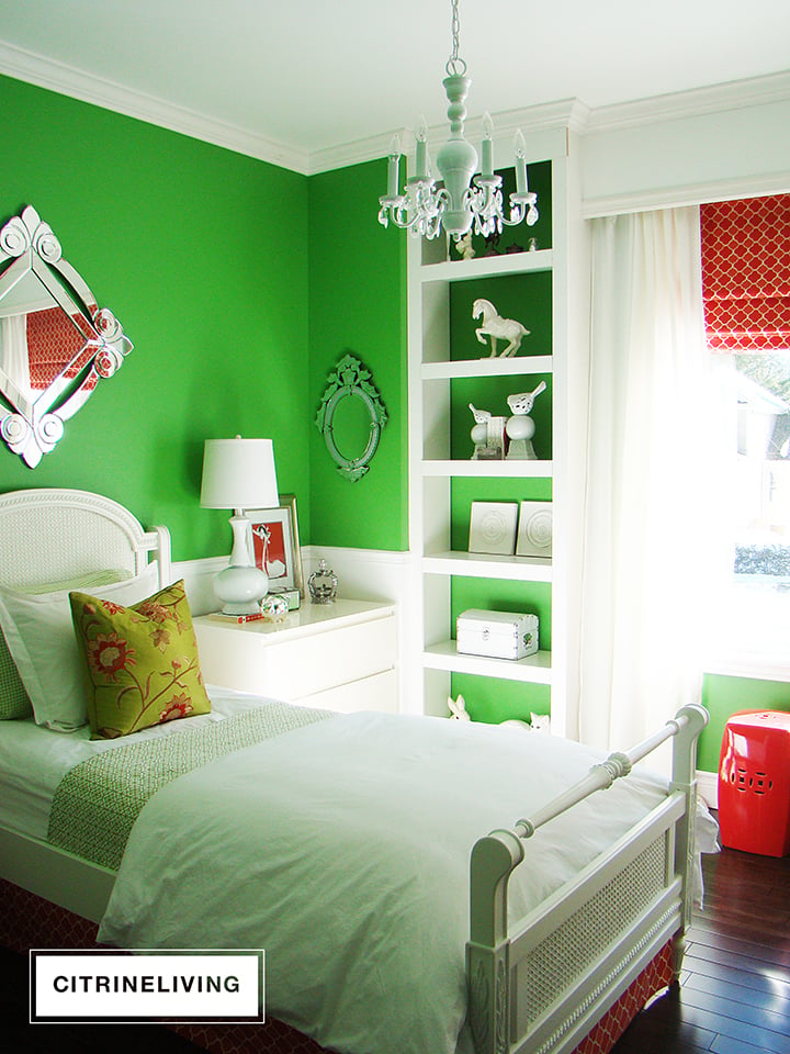 Girl's bedroom with kelly green walls, white millwork and coral accents.