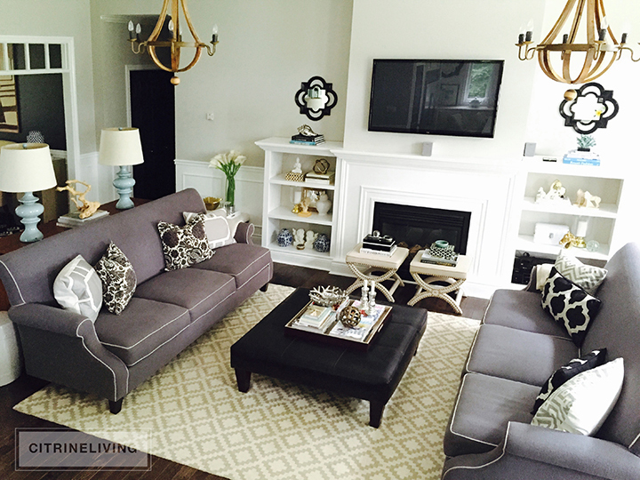 Living room before with dark grey couches and wine barrel chandeliers