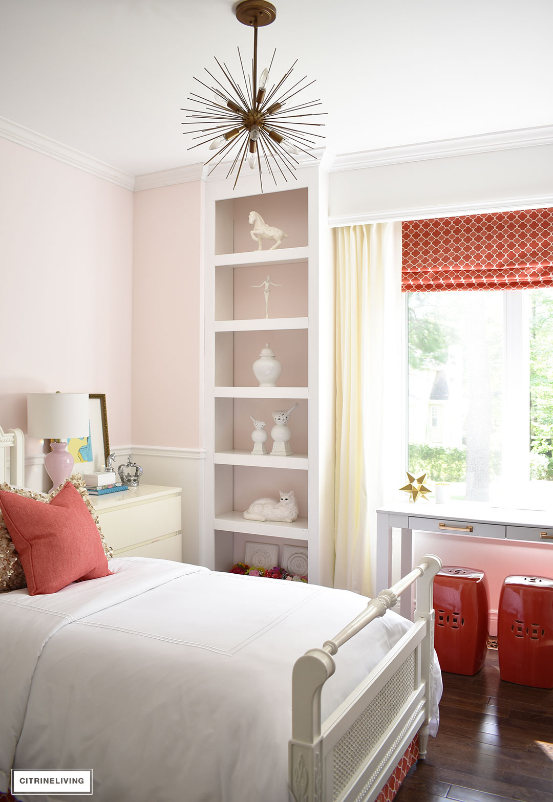 Girl's bedroom with blush pink walls, white trim, brass and coral accents.