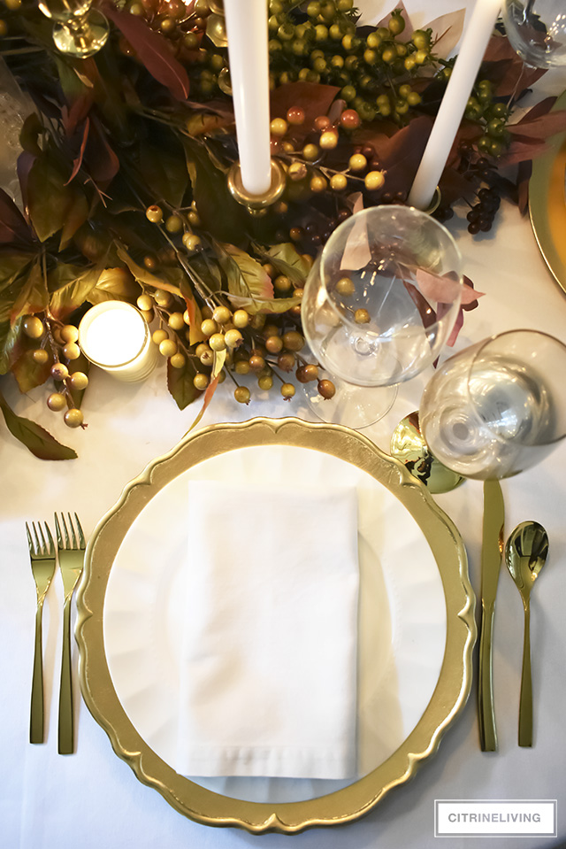 A white and gold Thanksgiving tablescape, with beautiful fall foliage in warm, earthy tones is a simple and elegant way to entertain for the holidays!