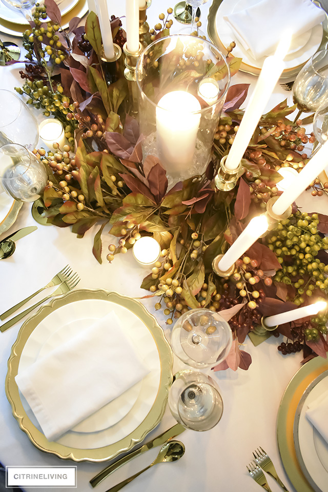 A white and gold Thanksgiving tablescape, with beautiful fall foliage in warm, earthy tones is a simple and elegant way to entertain for the holidays!
