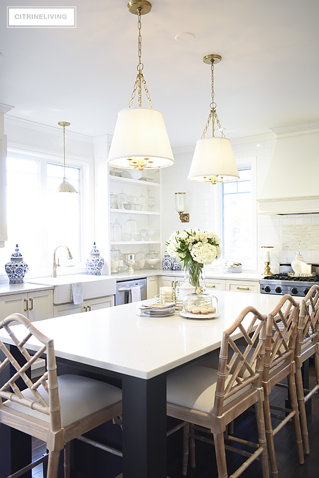 Kitchen pendant lighting with shades and chippendale barstools add chic sophistication to this space.