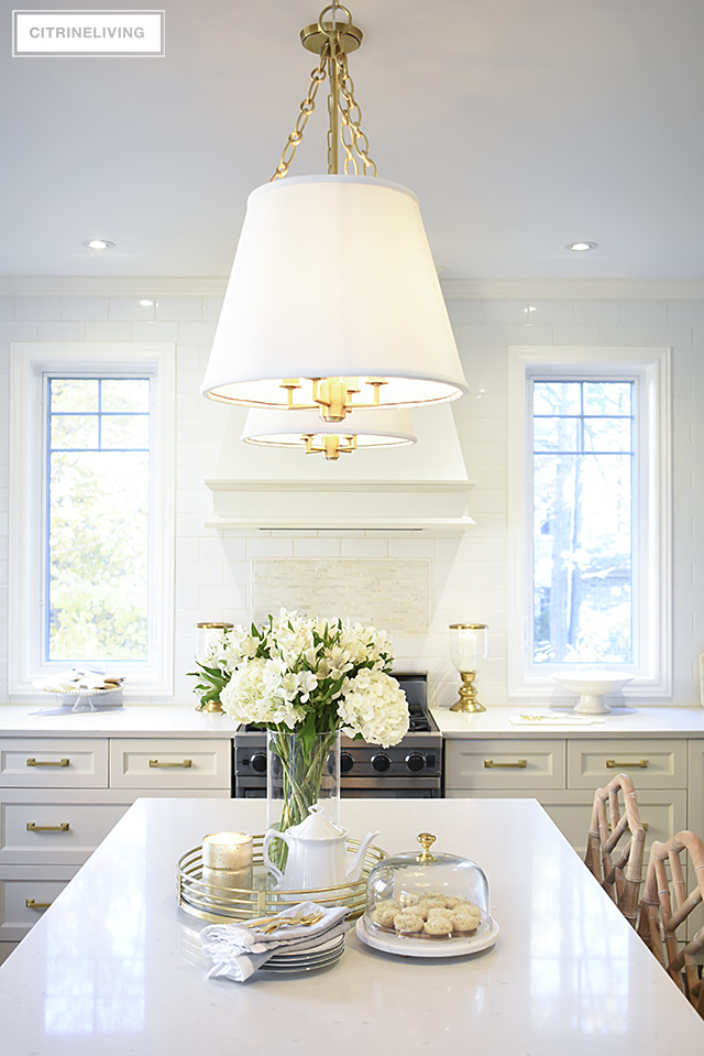 Tailored pendant lighting with shades and brass detailing is an elegant and chic addition in the kitchen.