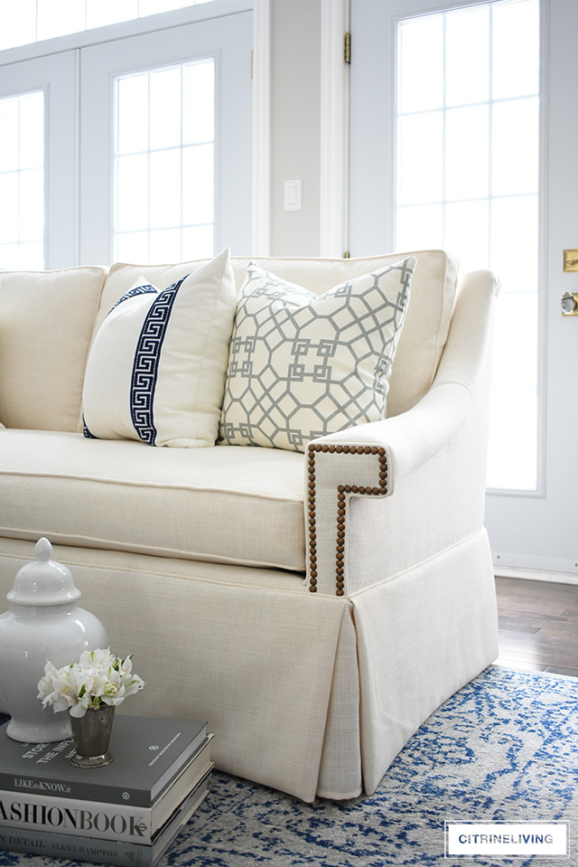 Gorgeous new white sofas with stunning details - brass nailhead trim, a sophisticated skirt, curved arms and bench cushion - these elegant and refined sofas elevate this living room to another level!