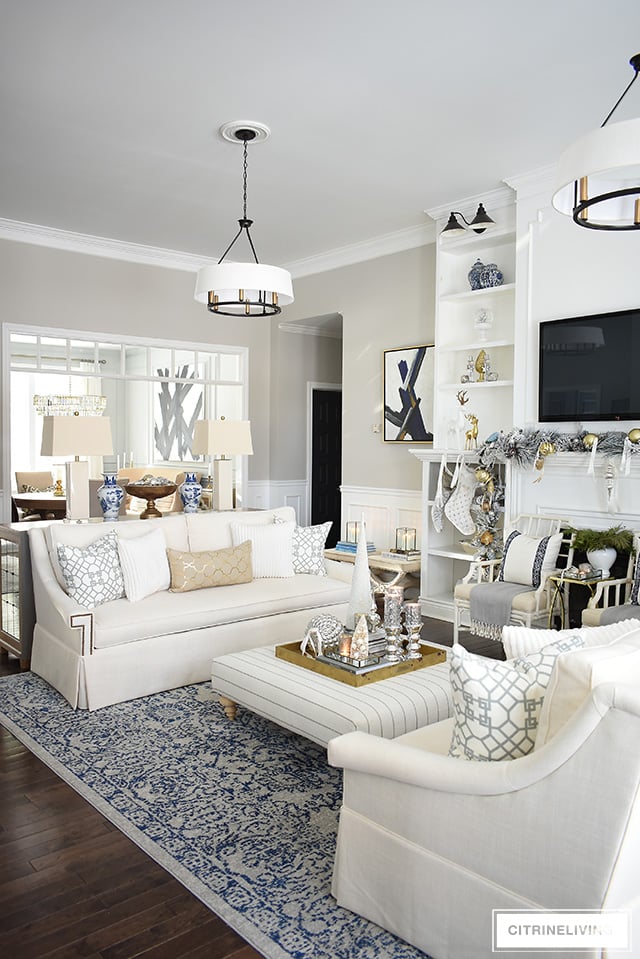 This newly updated living room is stunning, decorated for the holidays with a gorgeous flocked Christmas tree + garland, dressed in magical silver and gold!