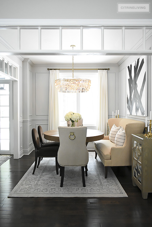 A gorgeous dining room makeover reveal with new gray walls and moldings, painted from the crown to the basboards. A spectacular chandelier sets the tone for this chic, sophisticated, bright and airy look.