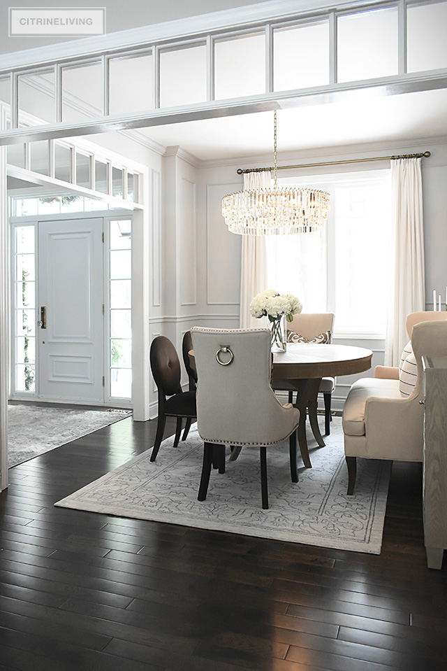 A gorgeous dining room makeover reveal with new gray walls and moldings, painted from the crown to the basboards. A spectacular chandelier sets the tone for this chic, sophisticated, bright and airy look.