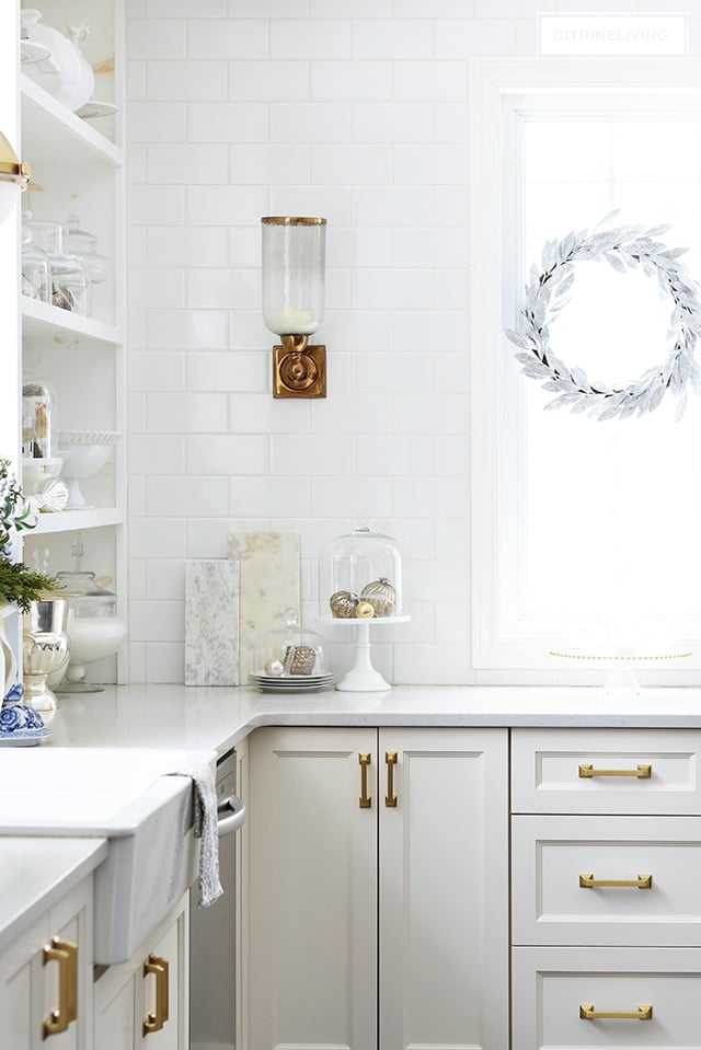 Christmas kitchen decorating using silver and gold mixed with touches of holiday greenery is the perfect mix of elegant and chic.