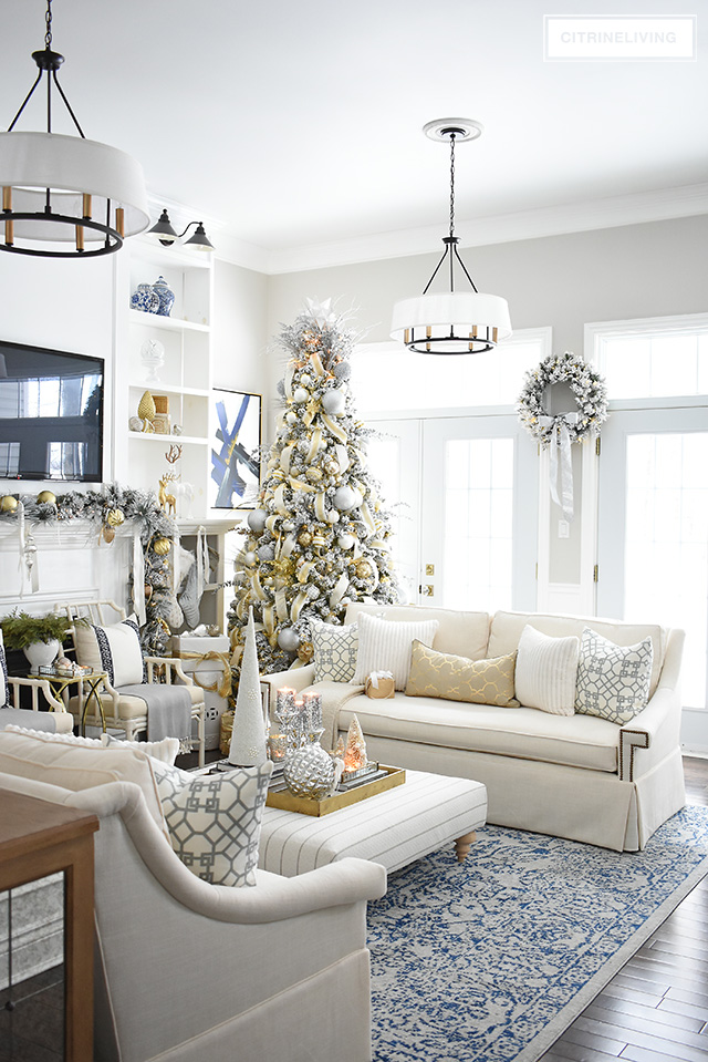 This newly updated living room is stunning, decorated for the holidays with a gorgeous flocked Christmas tree + garland, dressed in magical silver and gold!