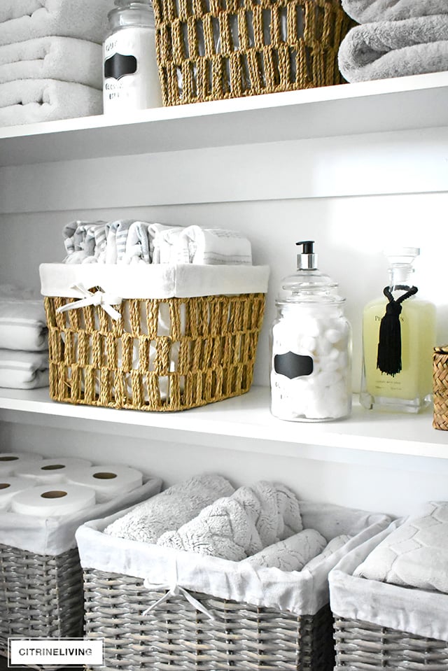 Organized linen closet reveal! A fresh coat of paint, pretty baskets and major purging, it went from messy and cramped to spacious and airy!