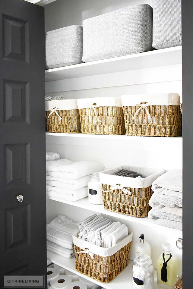 Organized linen closet reveal! A fresh coat of paint, pretty baskets and major purging, it went from messy and cramped to spacious and airy!