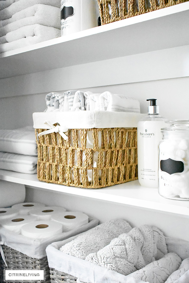 Organized linen closet reveal! A fresh coat of paint, pretty baskets and major purging, it went from messy and cramped to spacious and airy!