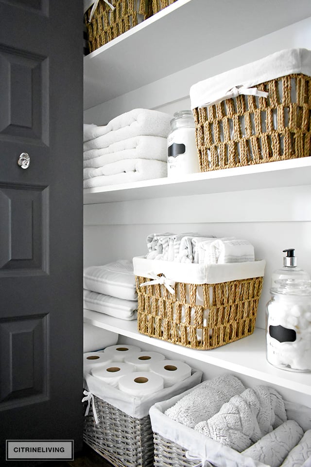 Organized linen closet reveal! A fresh coat of paint, pretty baskets and major purging, it went from messy and cramped to spacious and airy!