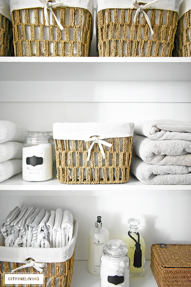 Organized linen closet reveal! A fresh coat of paint, pretty baskets and major purging, it went from messy and cramped to spacious and airy!