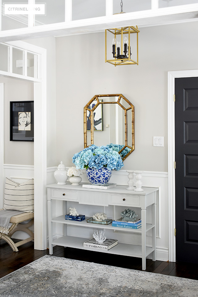 Spring entryway decorating - grey console table with oversized faux hydrangea arrangement and coral scullers create a gorgeous display!