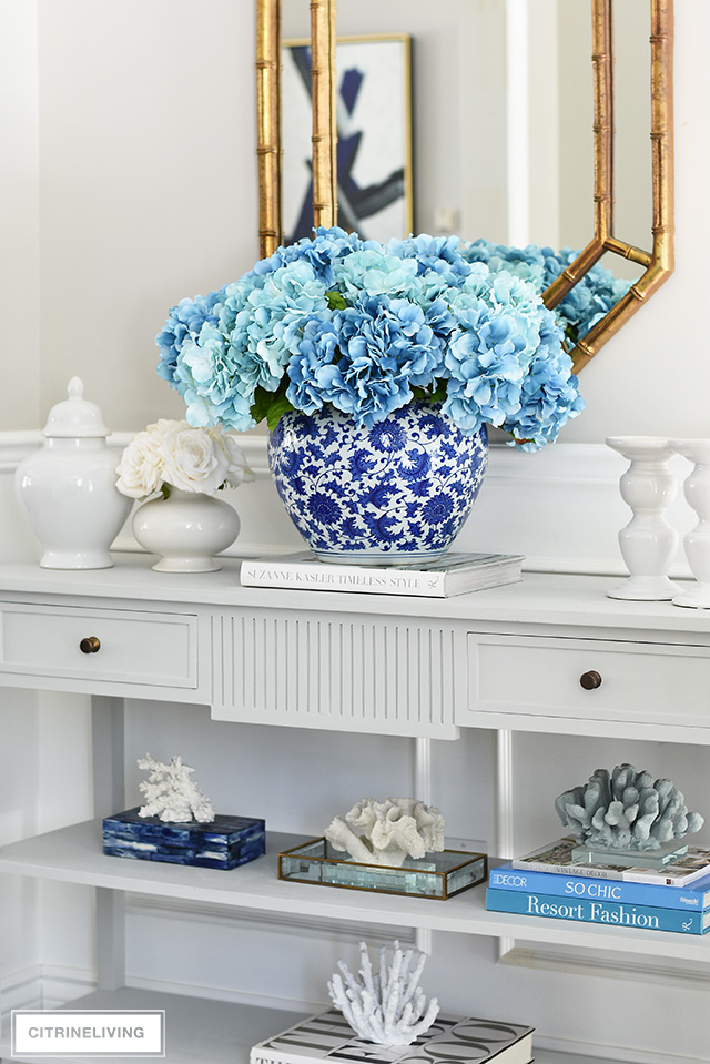 Beautiful and bold decorating with a large scale faux floral arrangement and a collection of coral.
