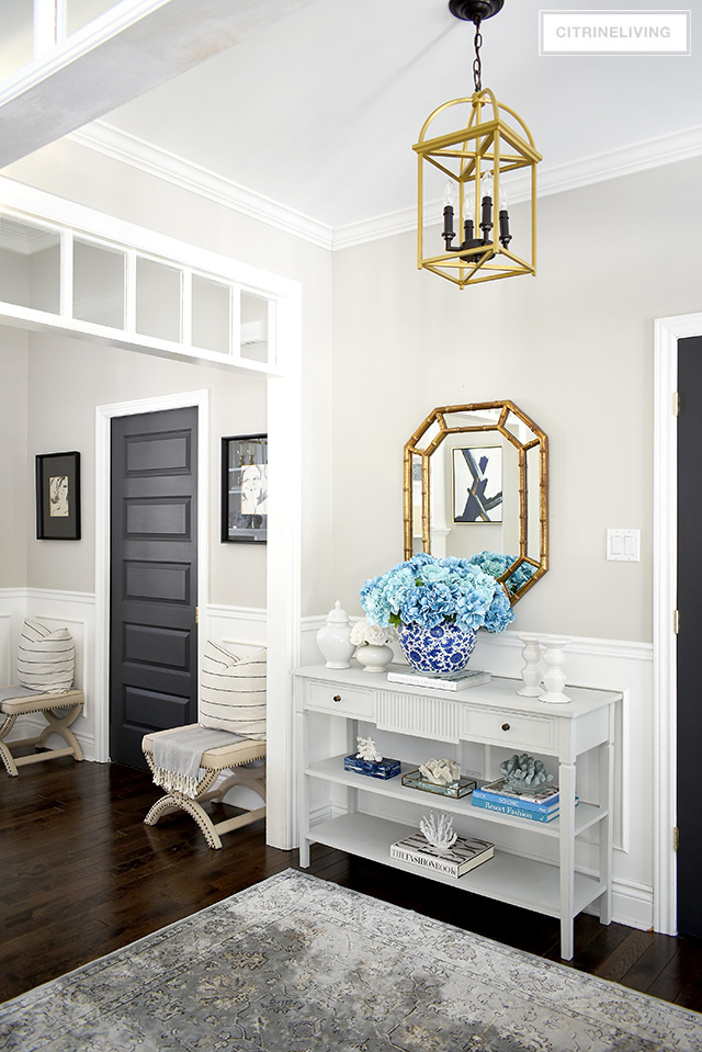 Beautiful Spring entryway decorating with a large faux hydrangea arrangement and beautiful coral sculptures.