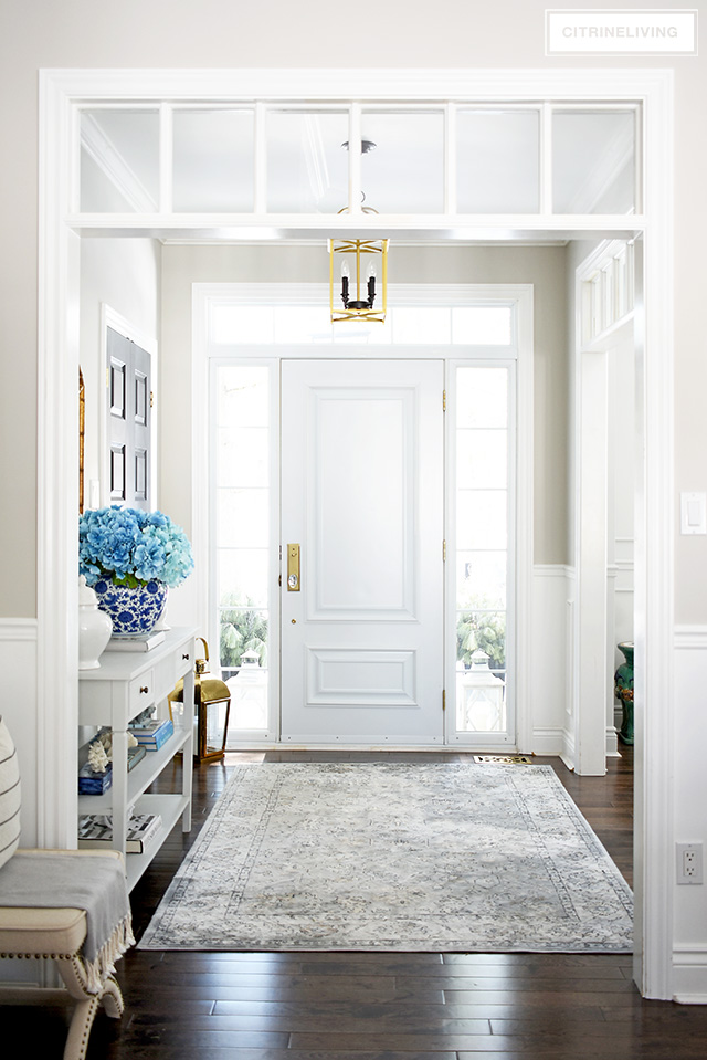 Welcoming entryway with blue, white and brass is fresh and beautiful for Spring!