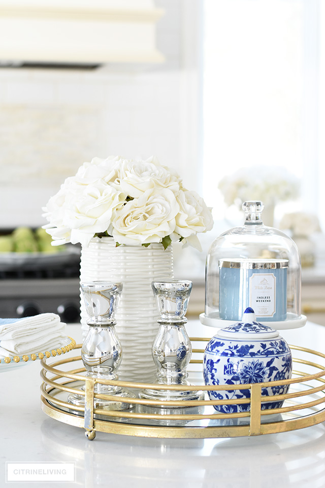 Spring decorating ideas - add a chic display to your island or table with a gold tray, beautiful florals, a scented candle - add blue and white touches for timeless elegance!