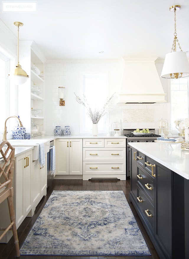 Gorgeous spring kitchen decorating ideas - light blue touches with faux flowers and a beautiful vintage rug help to celebrate the season!