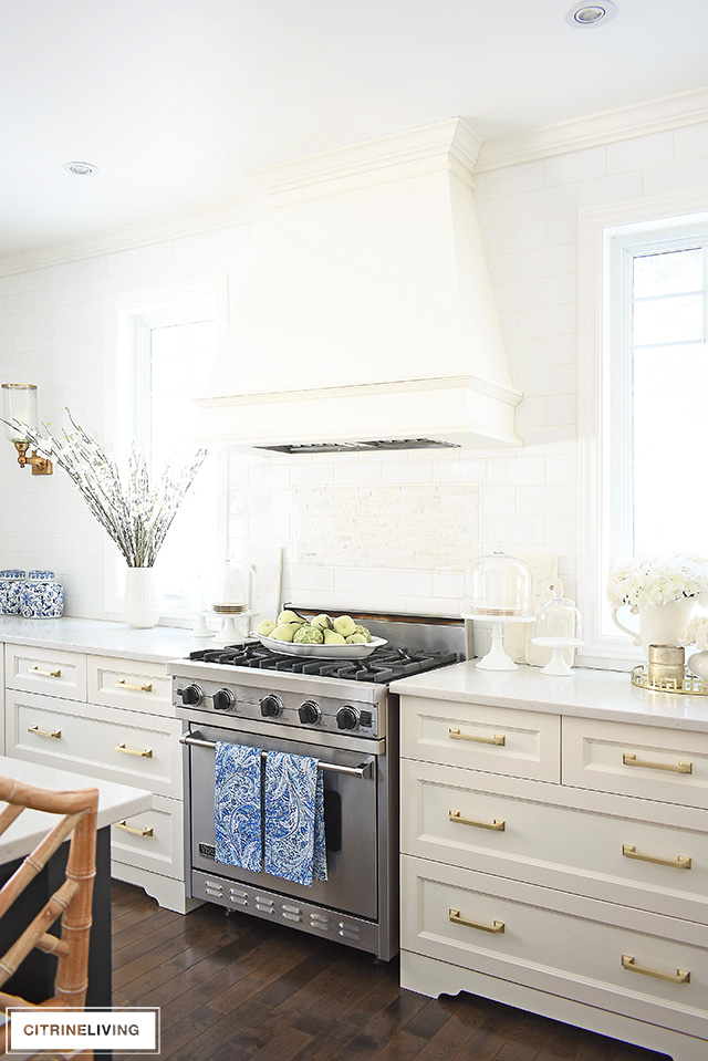 Spring decorating ideas - white kitchen with beautiful faux florals and blue and white touches.