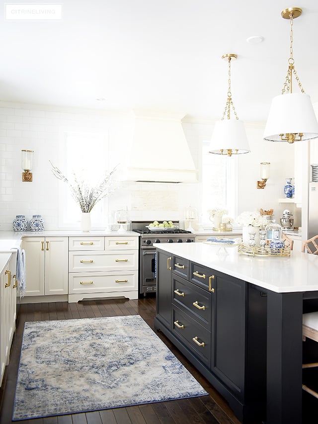 Spring kitchen decorating ideas - gorgeous white kitchen with vintage inspired rug, blue and white accents, faux florals and light blue touches.