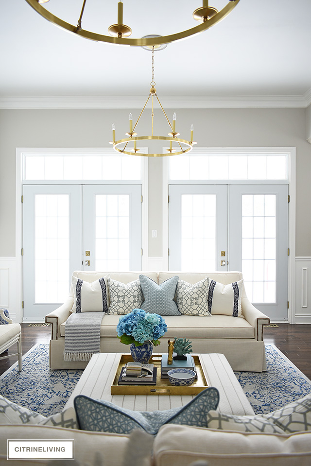 Beautiful and bright spring living room decorating in blue, white and brass plus our new gorgeous brass chandeiers and wall sconces!