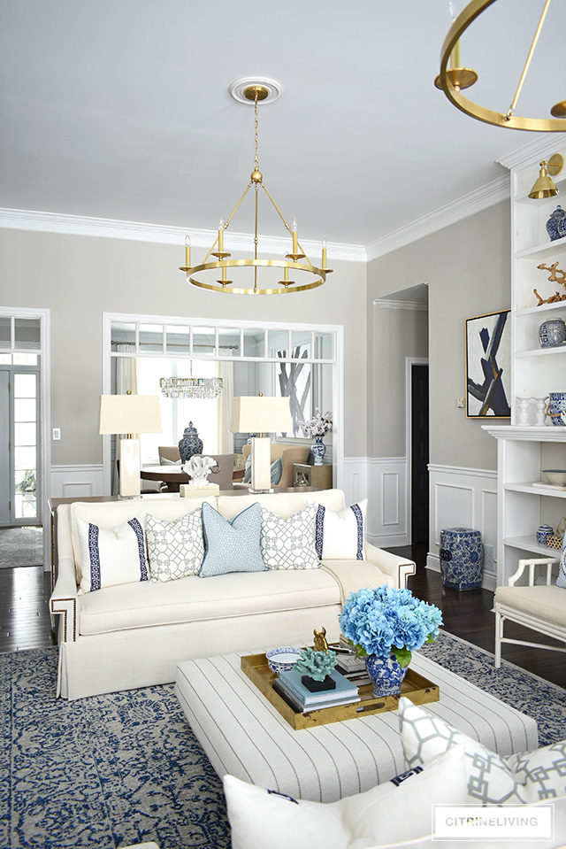 Beautiful and bright spring living room decorating in blue, white and brass plus our new gorgeous brass chandeiers and wall sconces!