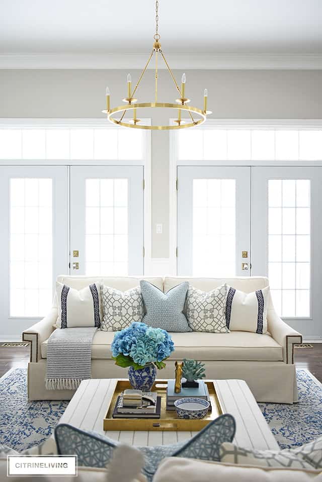 Beautiful and bright spring living room decorating in blue, white and brass plus our new gorgeous brass chandeiers and wall sconces!