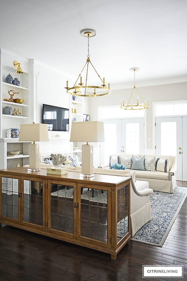 Beautiful and bright spring living room decorating in blue, white and brass plus our new gorgeous brass chandeiers and wall sconces!