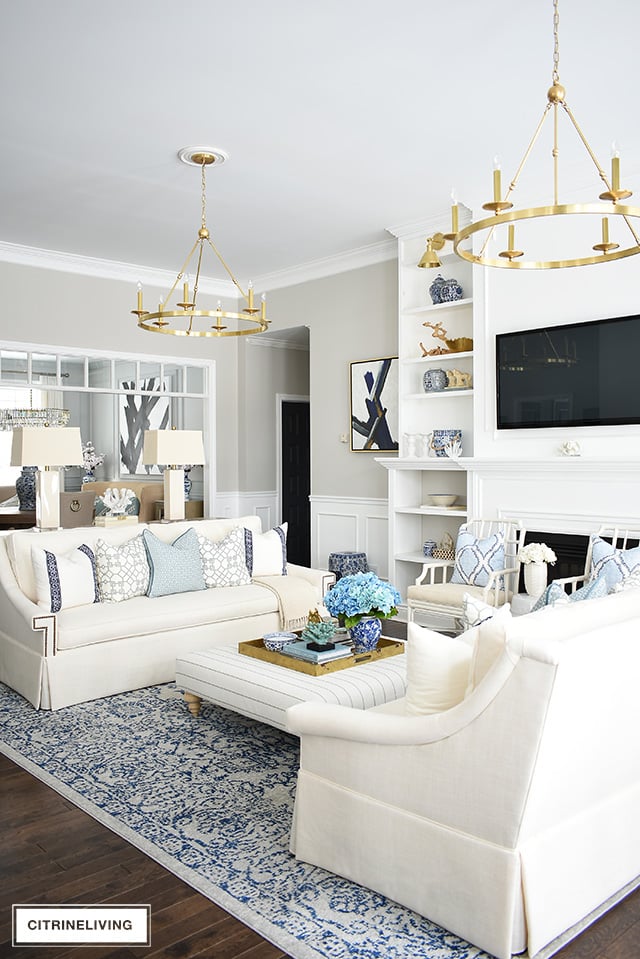 Beautiful and bright spring living room decorating in blue, white and brass plus our new gorgeous brass chandeiers and wall sconces!