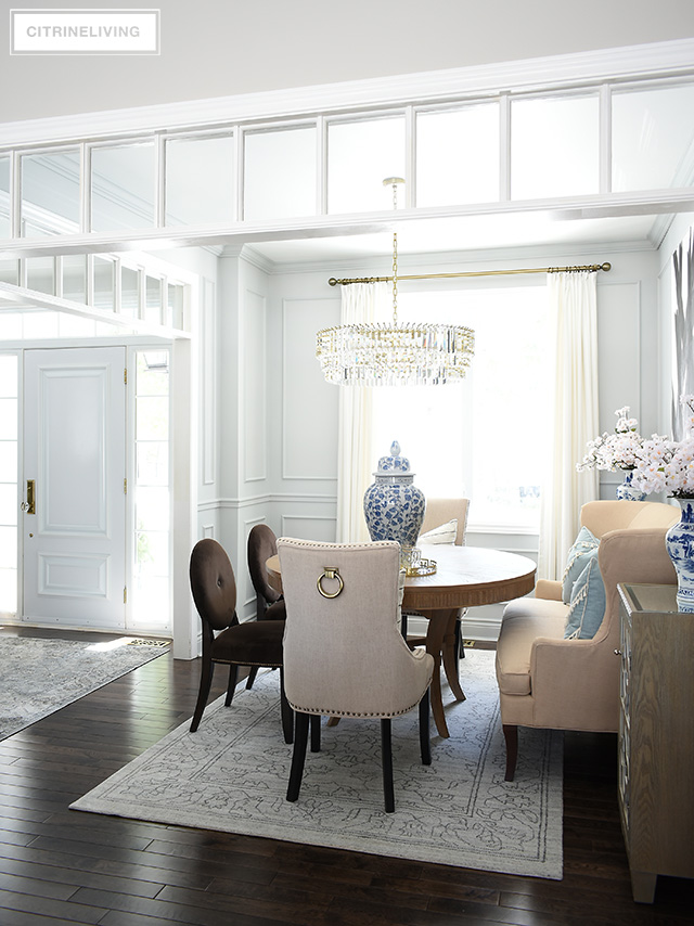 Gorgeous dining room with grey walls, moldings, crystal chandelier. Beautiful spring decor featuring blue and white chinoiserie.