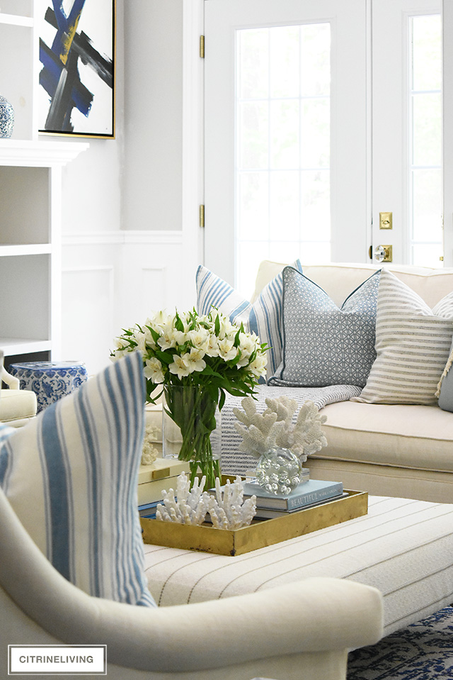 Beautiful bright and airy living rom with soft blues and creamy colors create an airy, coastal-chic look.