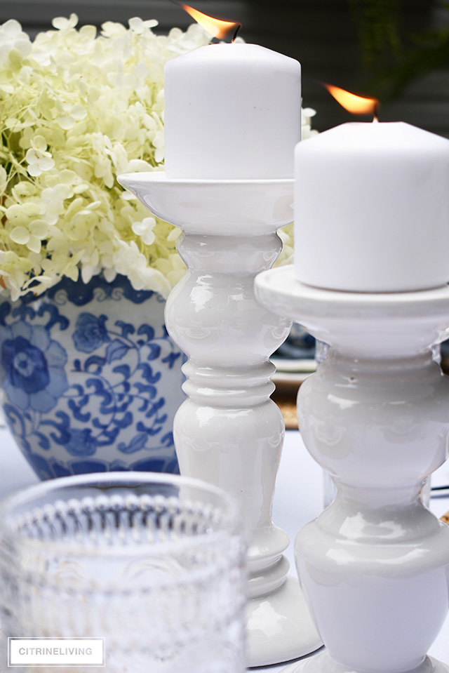 Vintage inspired outdoor late summer tablescape with white pillar candleholders.
