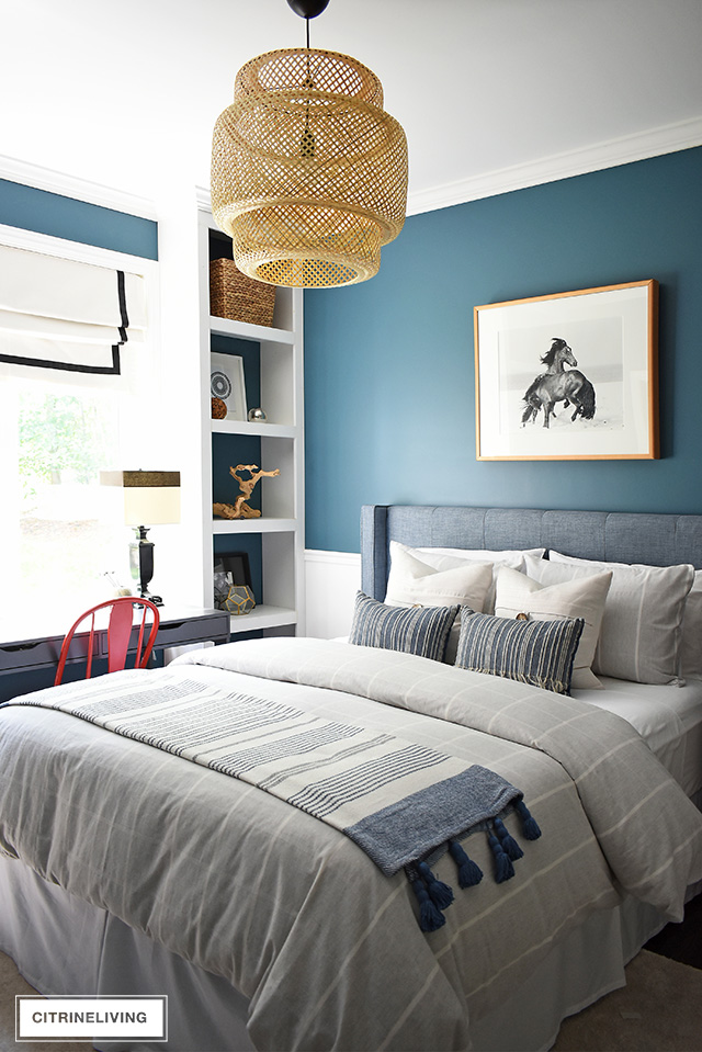Modern coastal teen bedroom with large-scale woven bamboo chandelier, striped bedding and pillows, modern decor on open shelves.