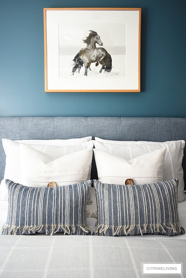 Modern coastal teen bedroom - striped and textured throw pillows paired with beach-themed horse photograph.