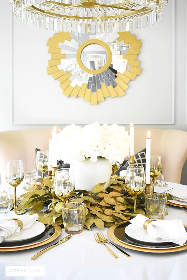 Beautiful luxe fall tablescape with an elegant centrepiece using faux hydrangeas and gold leaf picks. Black and white dishware are chic and sophisticated!