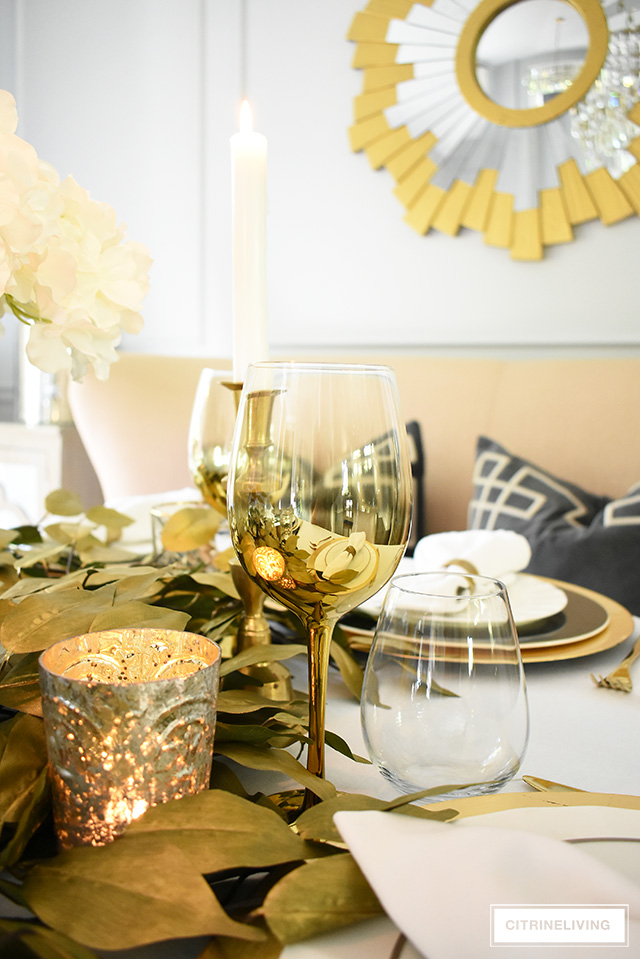 Beautiful luxe fall tablescape with gold wineglasses, mercury glass votives, gold charger plates and faux gold leaves are always elegant.