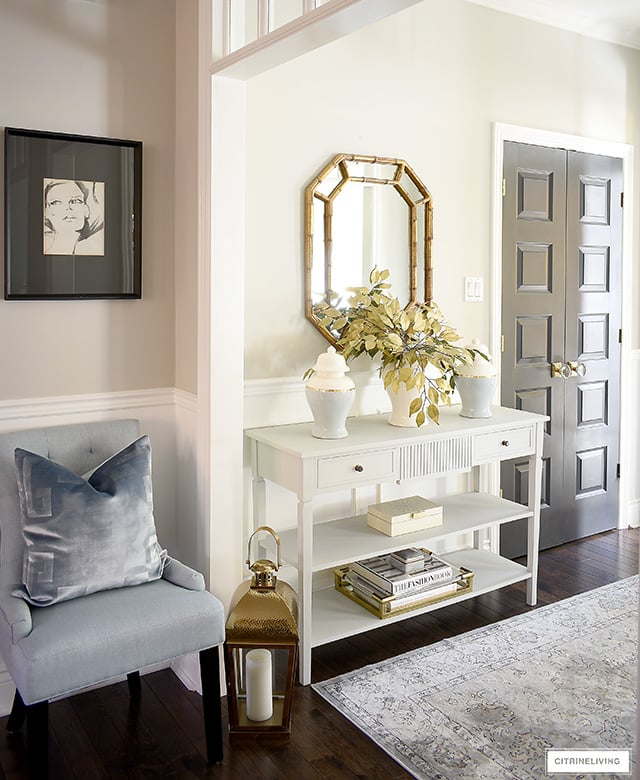 Fall entryway console table with chic ginger jars, faux gold leaves, gold mirror, gold tray, decorative box.