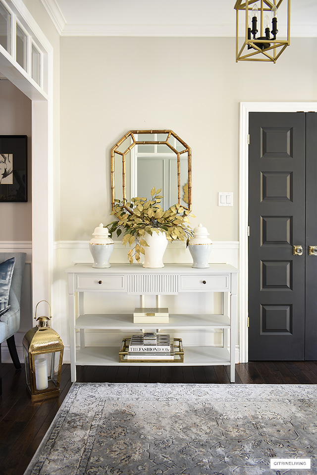 Elegant fall entryway with ginger jars, faux gold leaves, simple accessories.