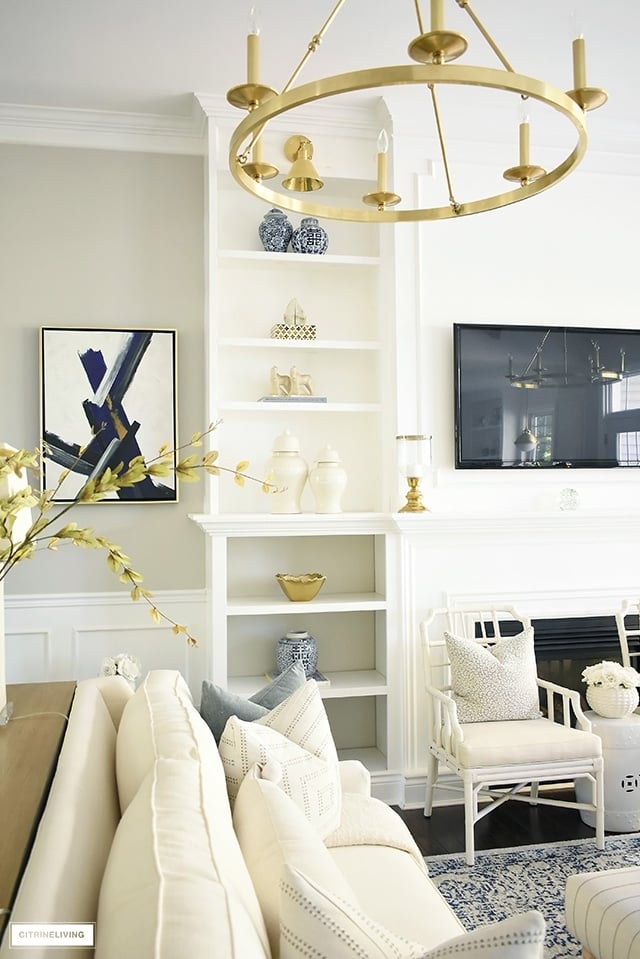 Elegant Fall living room with beautifully decorated bookshelves - ginger jars, gold accents and warm neutrals. are the perfect combination for setting the seen.