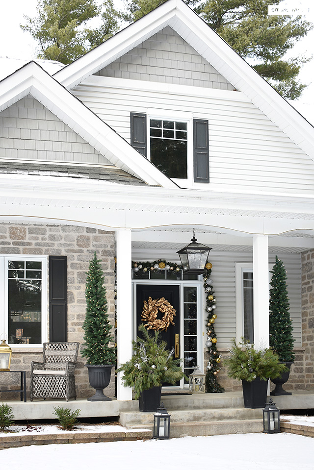 Front porch decorated for Christmas with elegant outdoor decor.