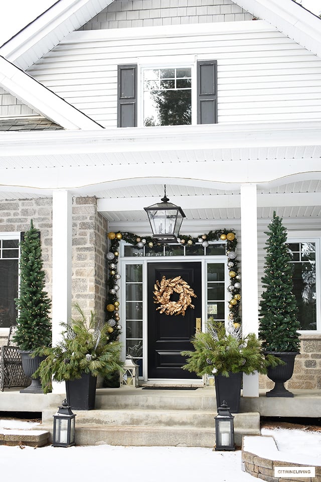 Front porch with gold and silver outdoor Christmas decorations.